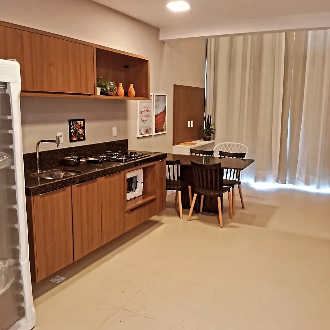 Cozinha integrada com sala de jantar, paredes claras e marcenaria em madeira