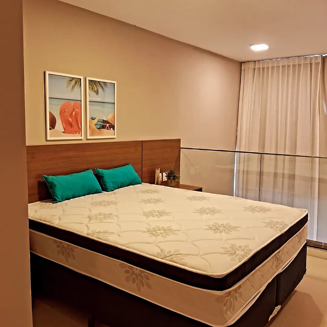 Segundo ângulo do quarto de casal, com parede de destaque em tom terroso